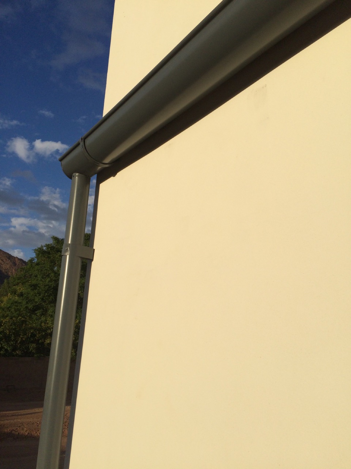 City Seamless half-round rain gutter with downspout routing on a custom home.