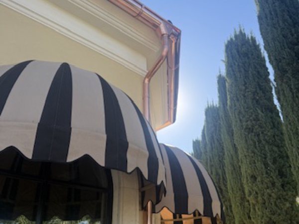 City Seamless half-round rain gutter with downspout routing on a custom home.