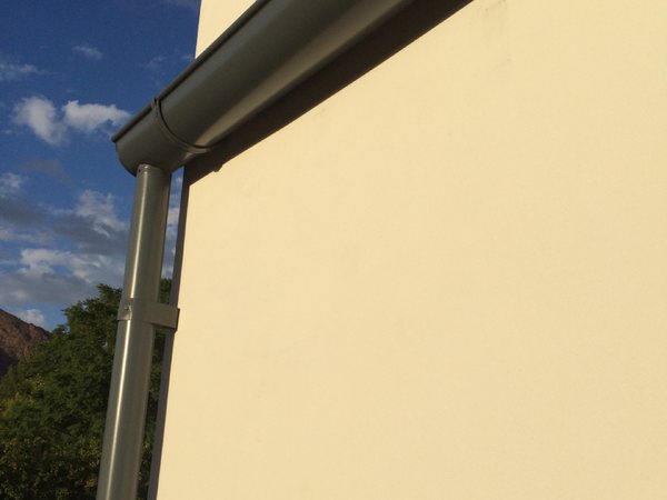 City Seamless half-round rain gutter with downspout routing on a custom home.