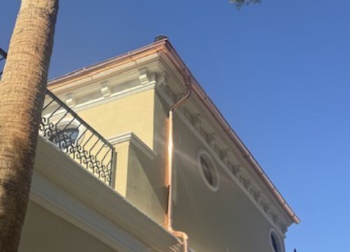 City Seamless half-round rain gutter with downspout routing on a custom home.